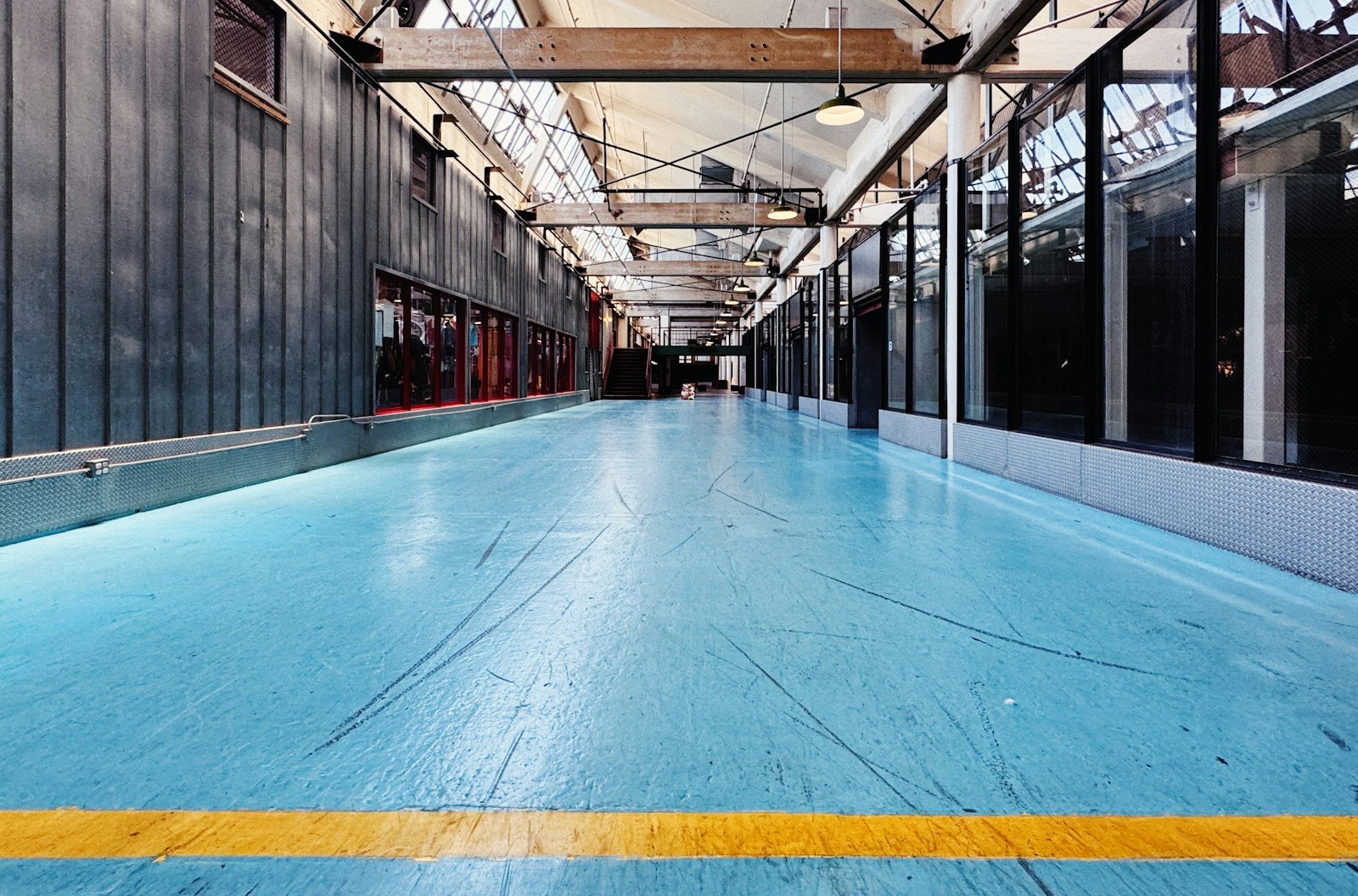 Large room with a blue coated floor and a yellow safety line